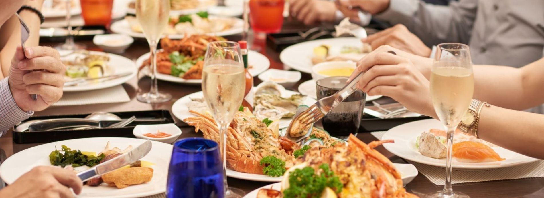 People eating at a table full of dinner plates and drinks