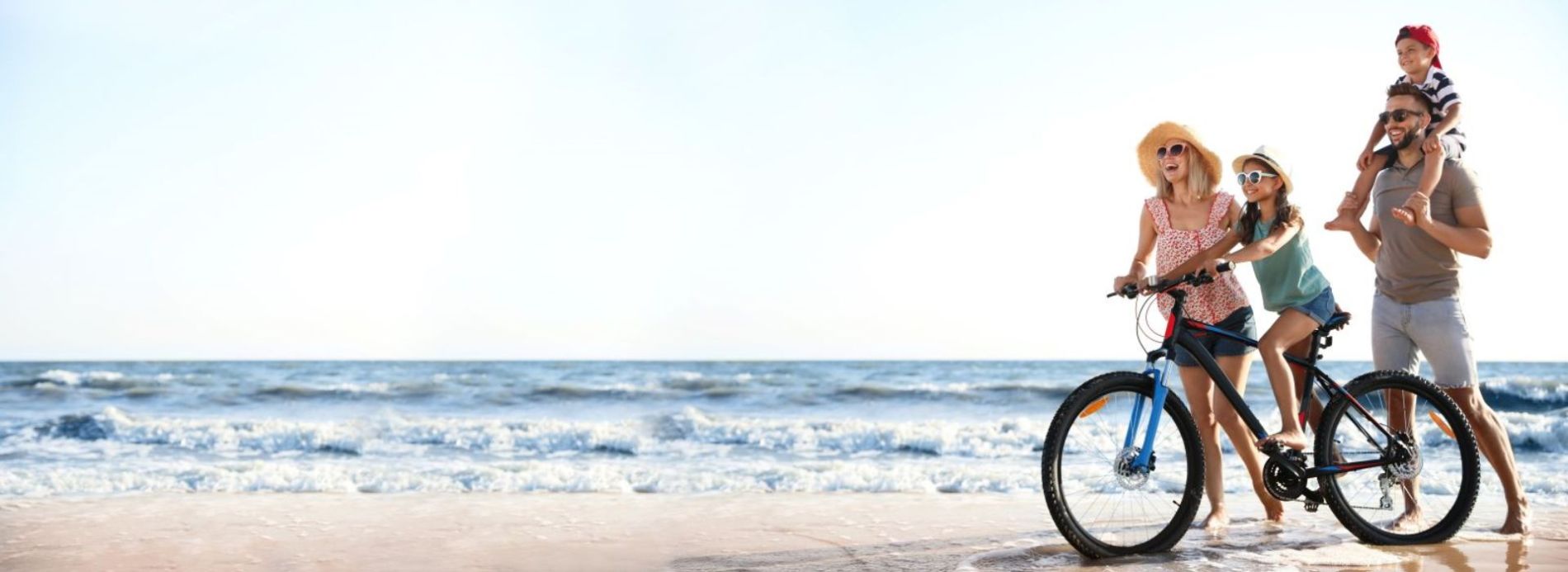 family riding a bike on the beach